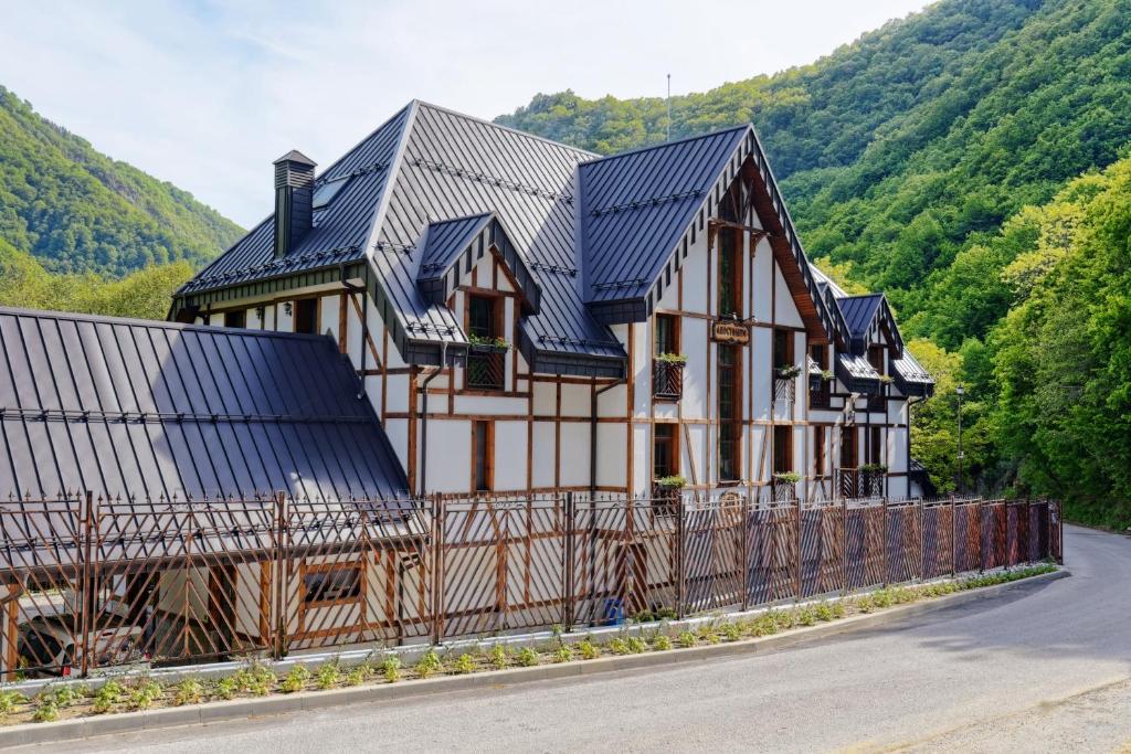 une maison avec un toit métallique sur le côté d'une route dans l'établissement Hotel Apostolite, à Sandanski