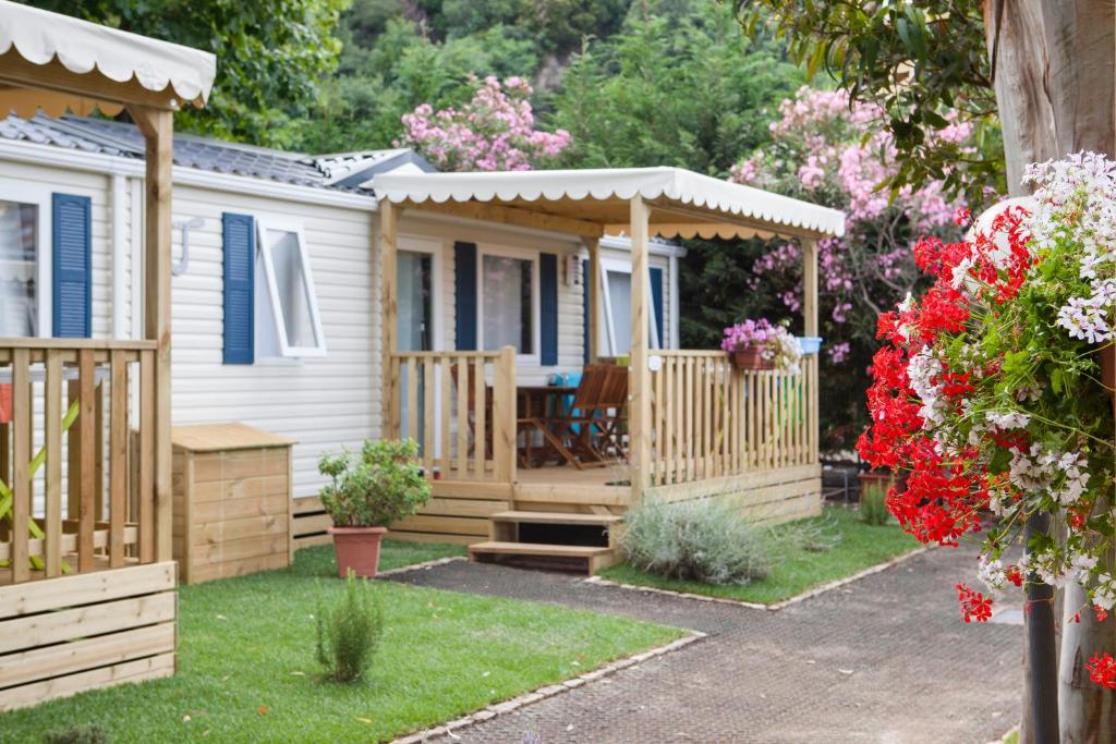 une maison avec une terrasse et un kiosque dans l'établissement Camping Delfino, à Albenga