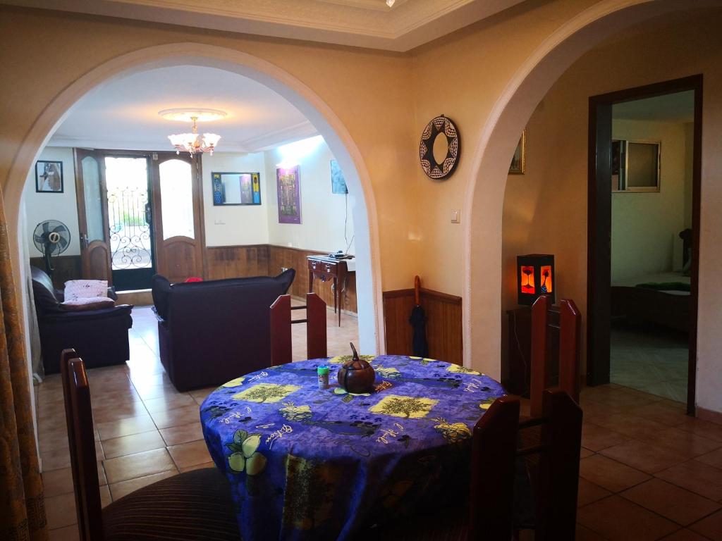 a living room with a table with a blue table cloth at Joli jardin en ville in Yaoundé