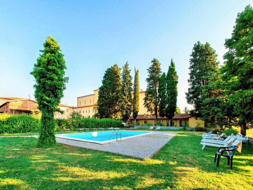 una piscina in un cortile con panchine e alberi di Residence La Poggerina a Figline Valdarno
