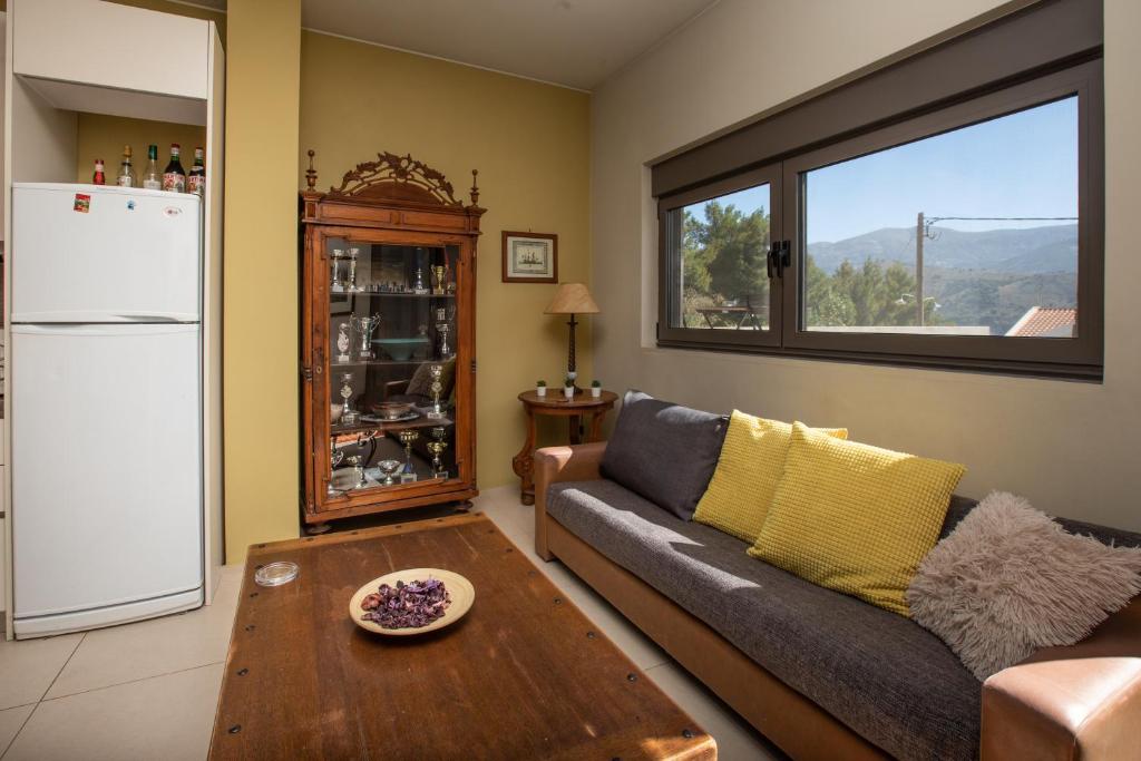 een woonkamer met een bank, een tafel en een koelkast bij The Pine Flat in Argostoli