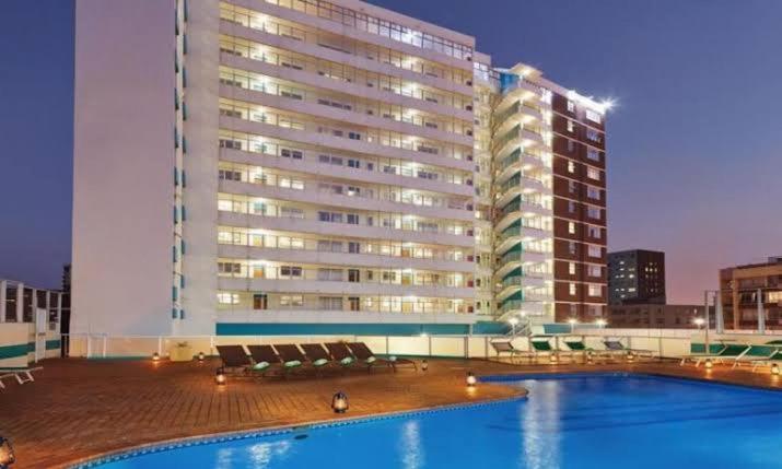 德班的住宿－10 South Apartments，一座大型建筑,在一座建筑前设有一个游泳池