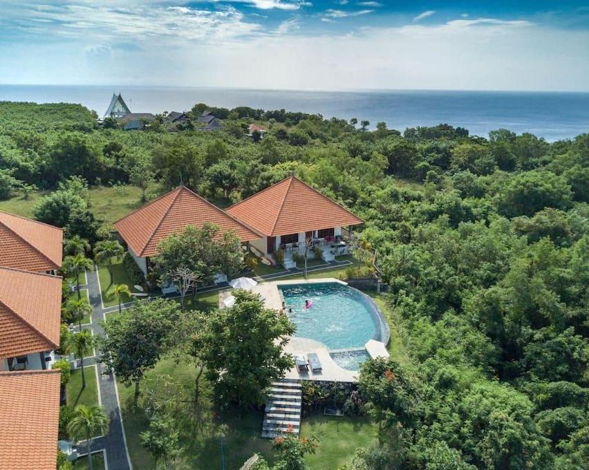 een luchtzicht op een huis met een zwembad bij Batu Jaran Hill Cottage Uluwatu in Uluwatu
