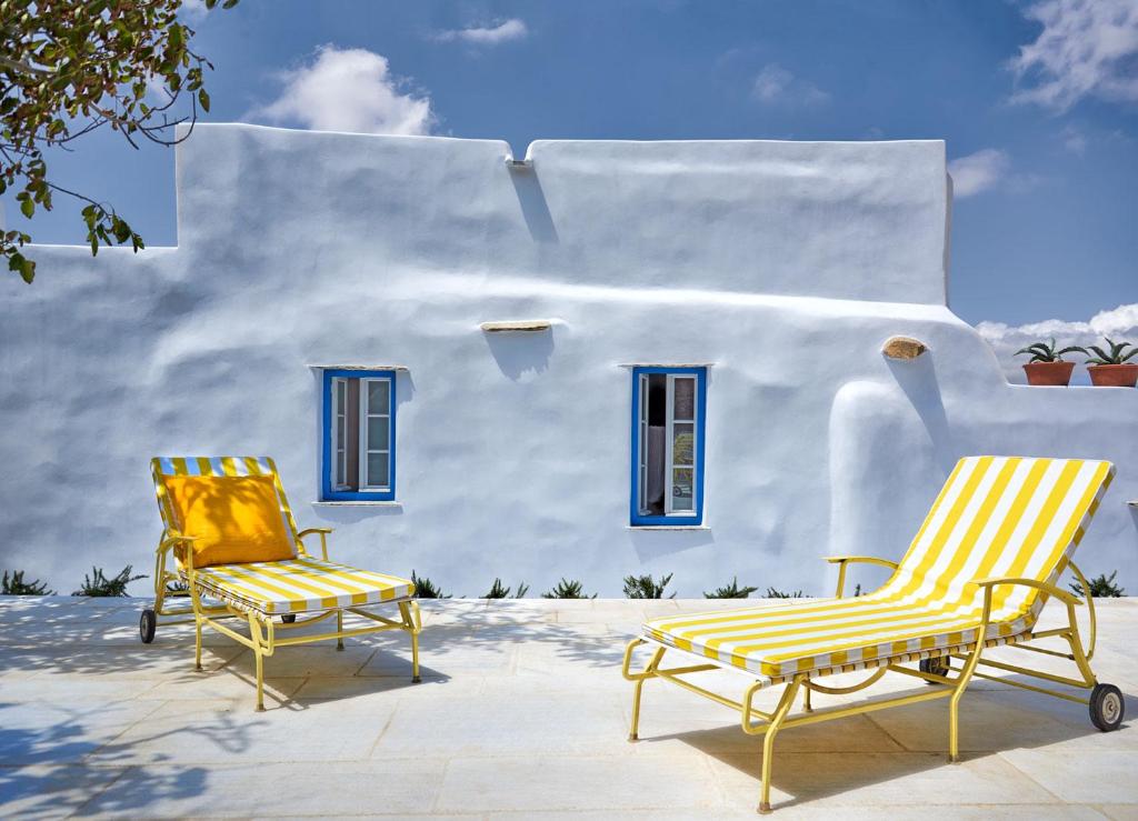 two chairs sitting in front of a white building at Xinara House in Tripótamos