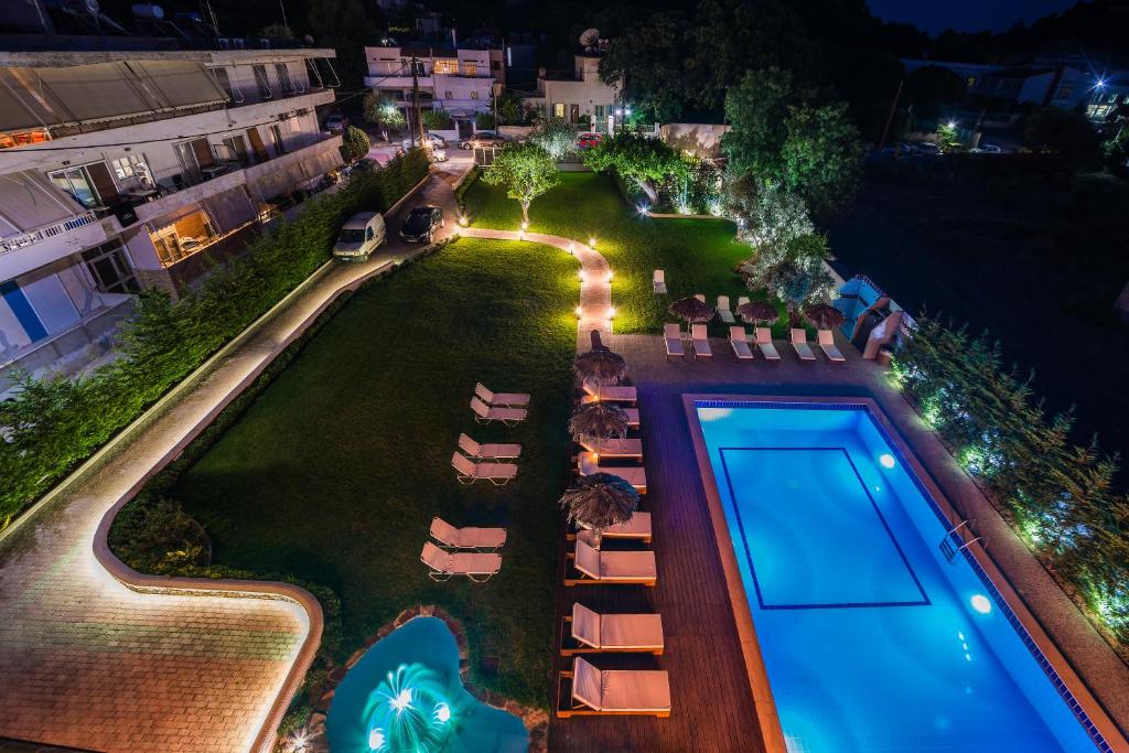 uma vista superior de uma piscina à noite em Maritina Apartments em Ixia