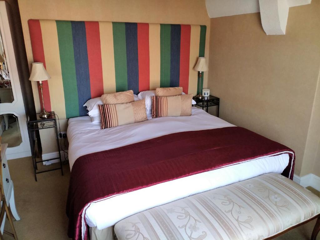 Dormitorio con cama grande y cabecero colorido en Bay Tree House Southport, United Kingdom, en Southport