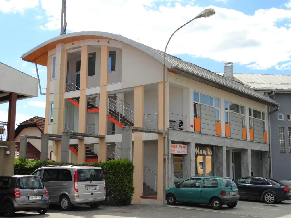 un edificio con auto parcheggiate in un parcheggio di Rooms K a Maribor