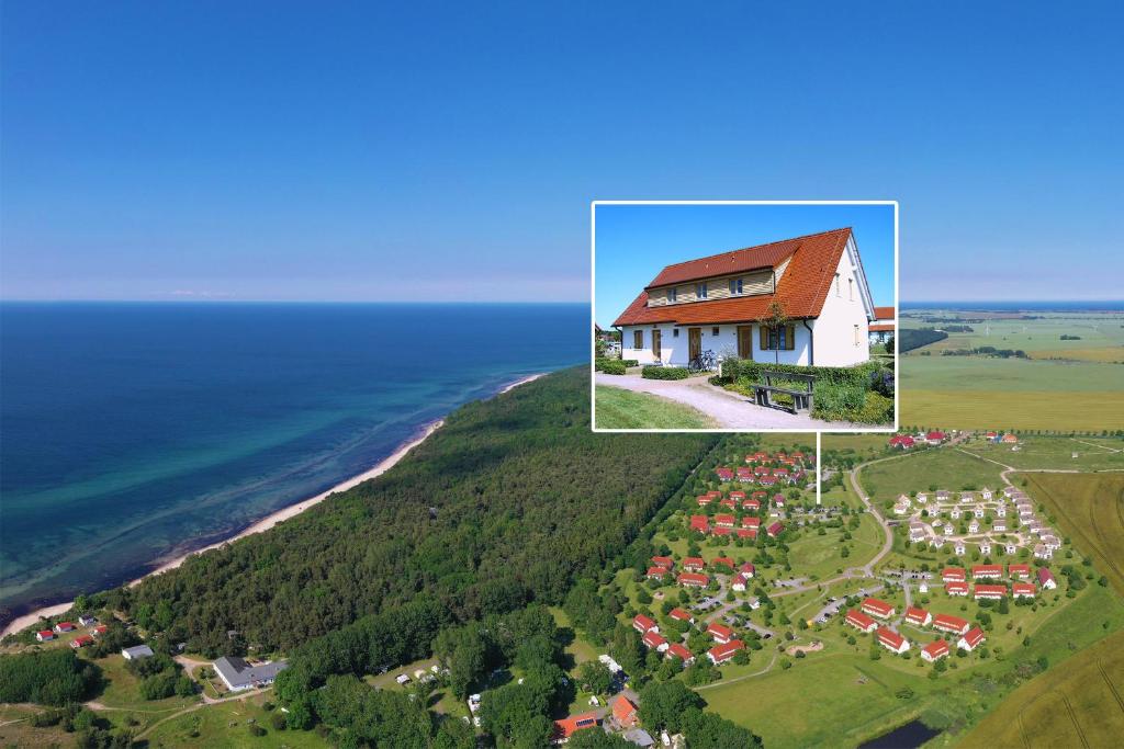 ein großes Haus auf einem Hügel neben dem Meer in der Unterkunft Feriendorf am Bakenberg in Dranske