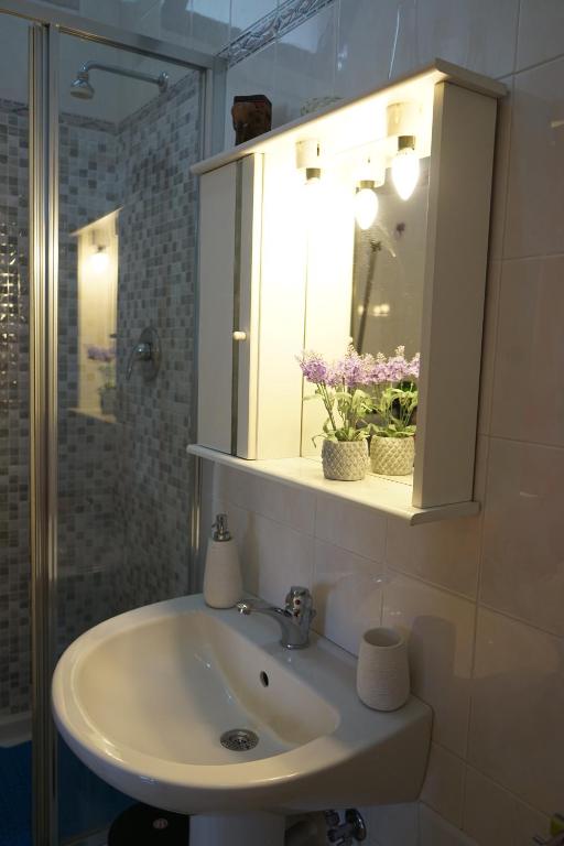 umywalkę w łazience z szafką z lekami i lustrem w obiekcie A Casa Mia w mieście Giffoni Valle Piana