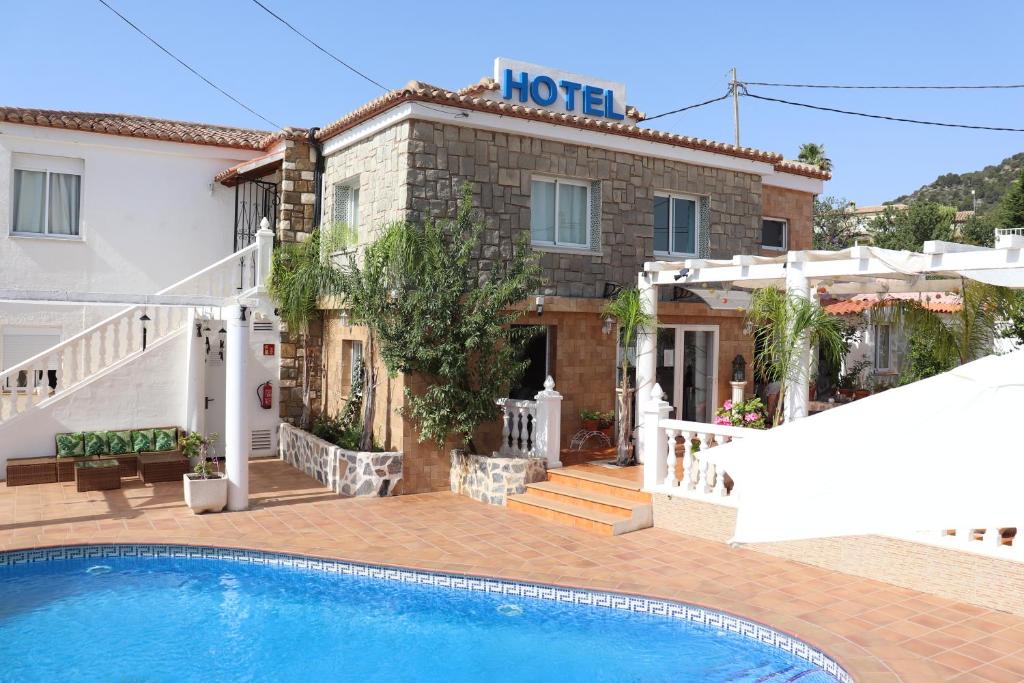 a hotel with a swimming pool in front of a building at Hotel Casa Día y Noche in Calpe