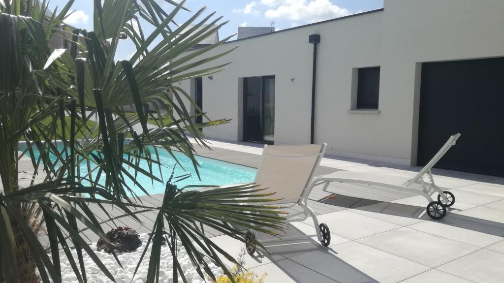 a patio with two chairs and a swimming pool at La casita de Vanessa in Changé