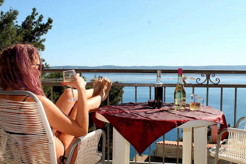 two women sitting at a table with glasses of wine at Entire home with a swimming pool for 12 in Marusici in Marusici 