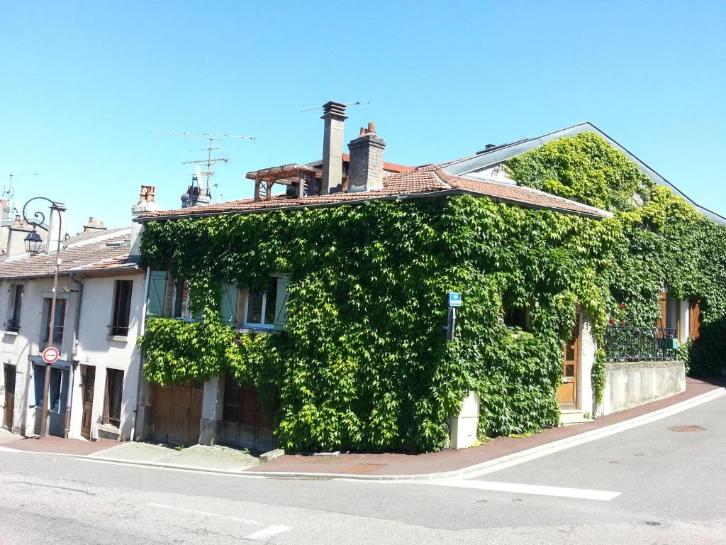 a building covered in ivy on the side of a street at Maison-Gite métropole Nancy in Vandoeuvre-lès-Nancy