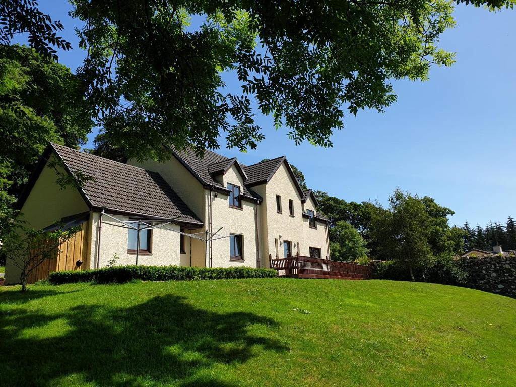 a large white house on a green lawn at Stonefield House in Portree