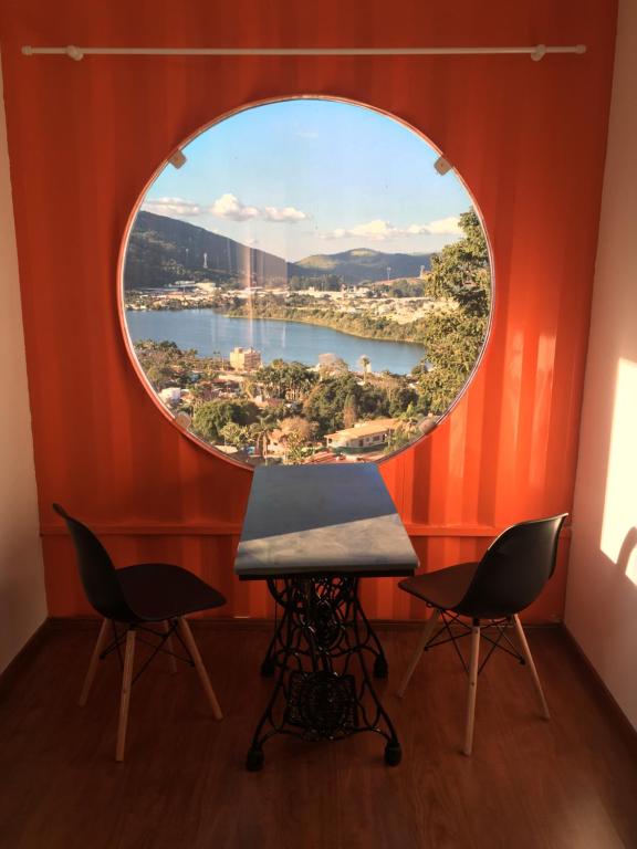 a circular window in a room with two chairs and a table at Amsterdam lofts 4 in Poços de Caldas