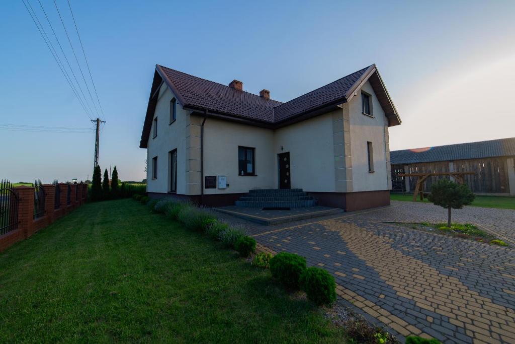 una pequeña casa blanca con techo rojo en Agroturystyka Nowa Wólka, en Łęczna