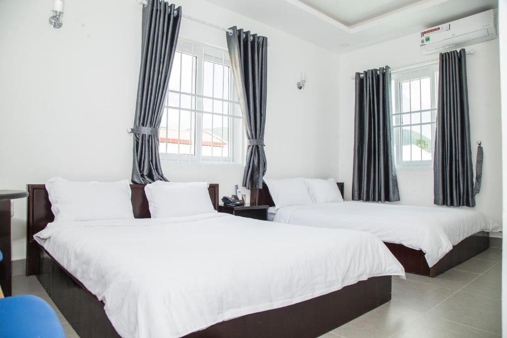 dwa łóżka w pokoju z dwoma oknami w obiekcie THAO LIEN HOTEL w mieście Con Dao