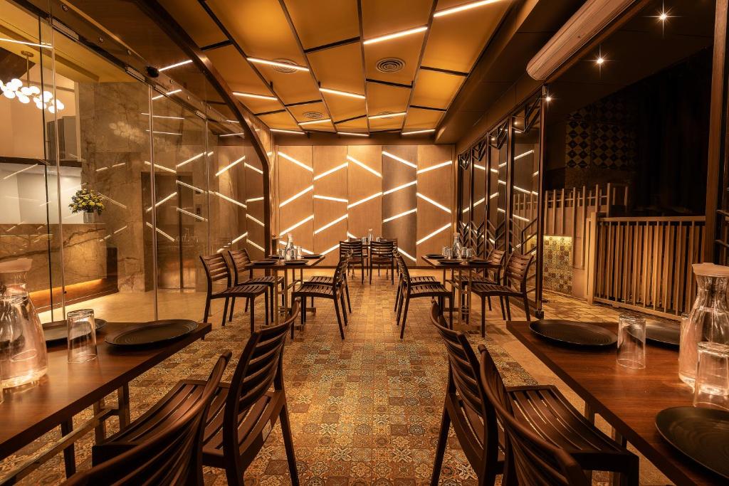 a dining room with wooden tables and chairs at Hotel Metropole Inn in Mumbai