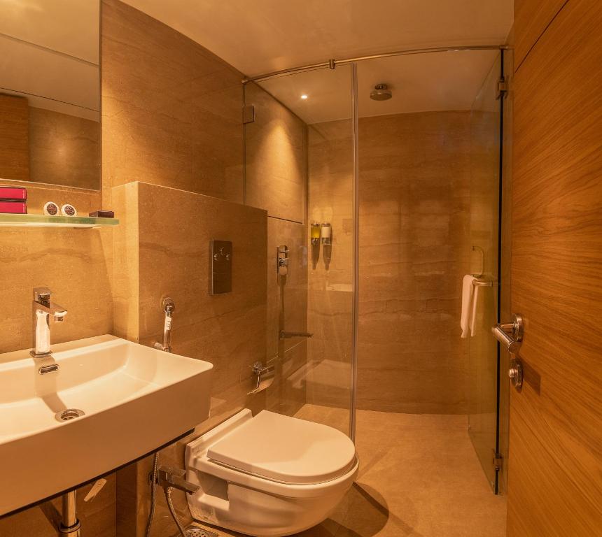 a bathroom with a toilet and a sink and a shower at Hotel Metropole Inn in Mumbai