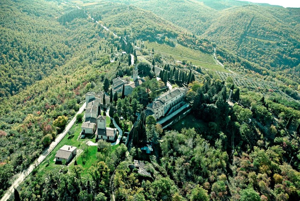 a large building with trees and mountains at Borgo Di Pietrafitta Relais in Castellina in Chianti