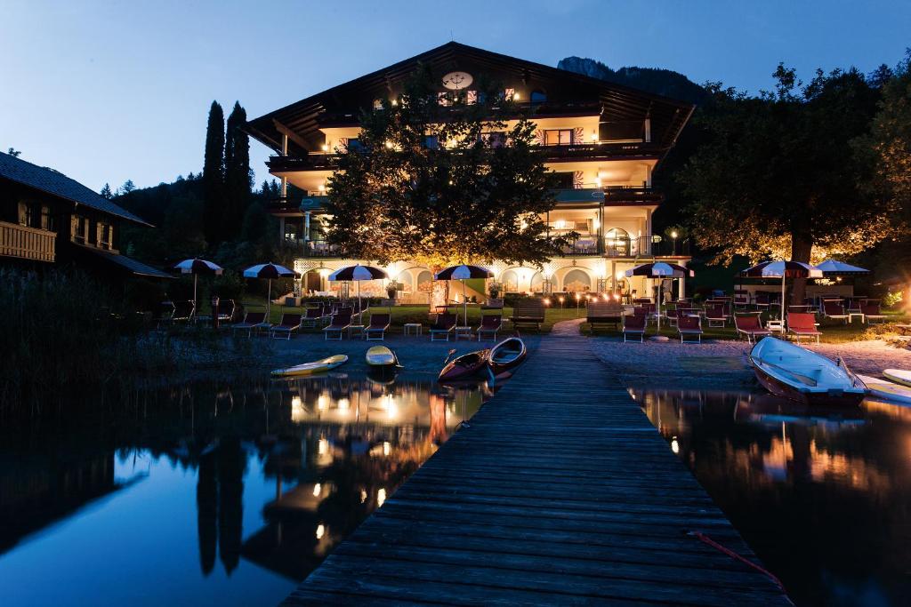 a building with boats in the water at night at Hotel Seewinkel in Fuschl am See