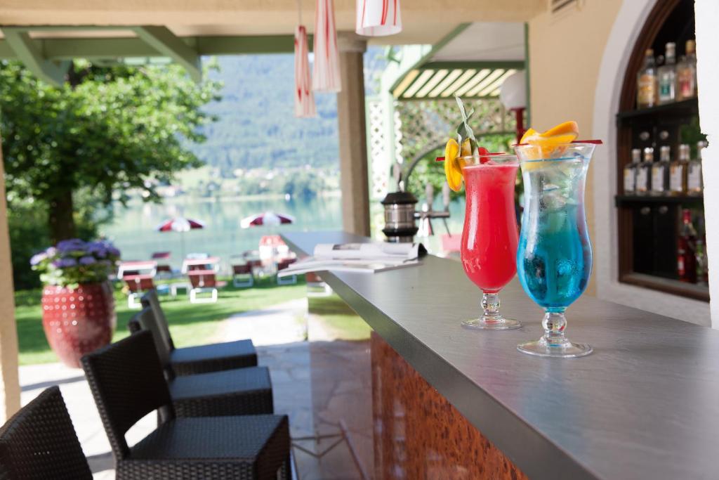 two cocktails sitting on a bar in a restaurant at Hotel Seewinkel in Fuschl am See