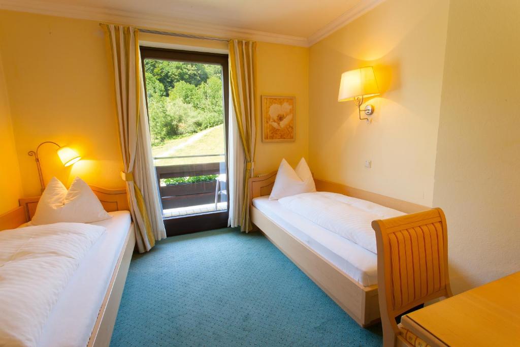a hotel room with two beds and a window at Hotel Seewinkel in Fuschl am See
