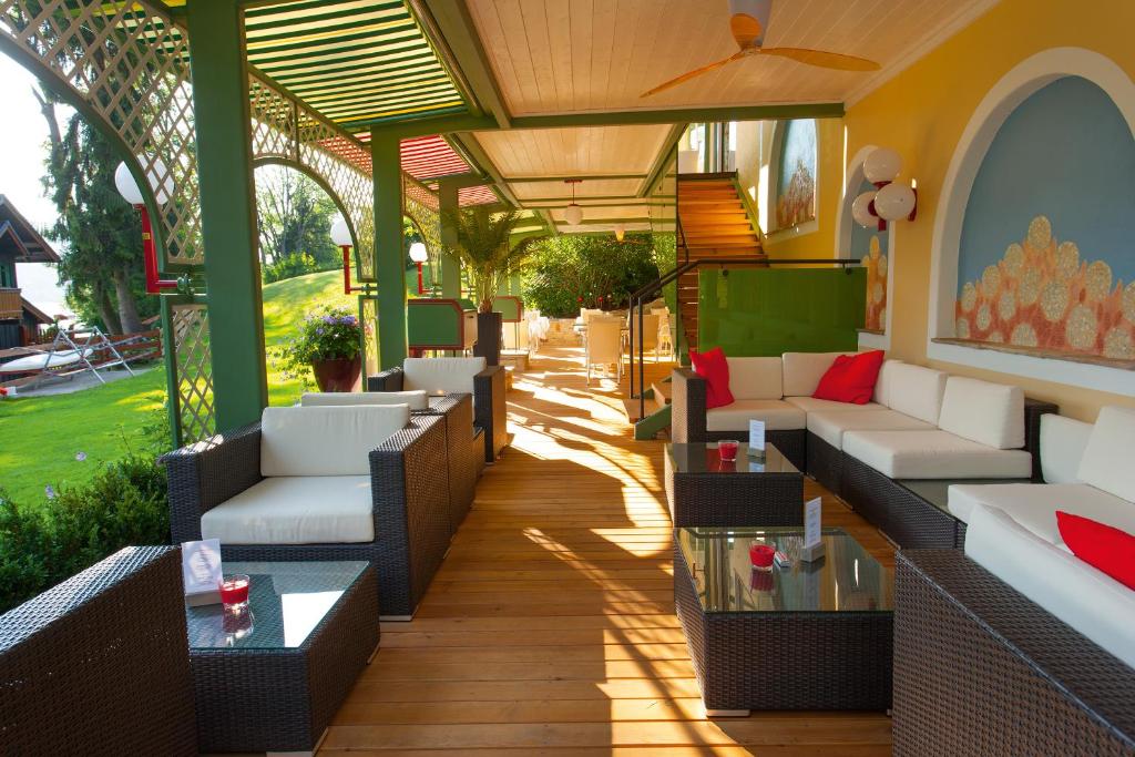 an outdoor patio with couches and tables at Hotel Seewinkel in Fuschl am See