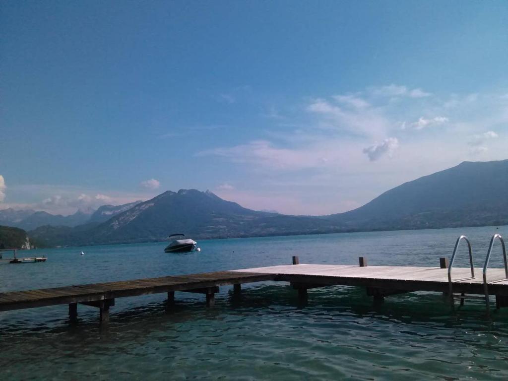 un quai sur un lac avec un bateau dans l'eau dans l'établissement Appartement dans villa accès privé au lac, à Veyrier-du-Lac