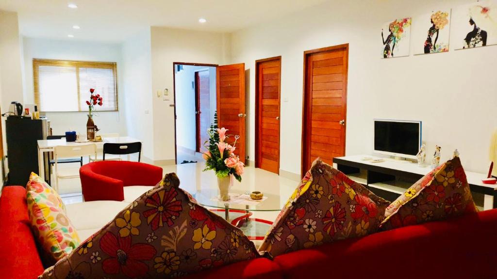 salon z czerwoną kanapą i czerwonym krzesłem w obiekcie Siray House w Phuket