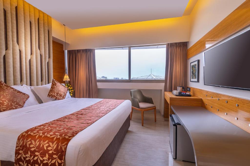 una camera con letto e TV a schermo piatto di Hotel Metropole Inn a Mumbai