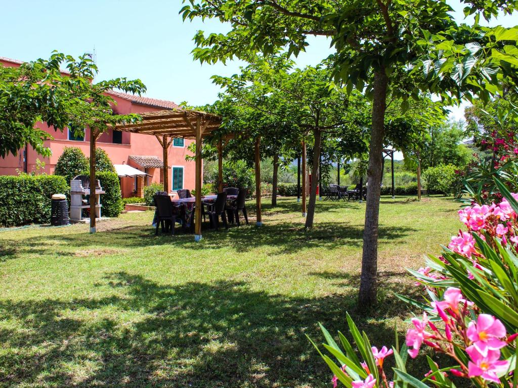 Bed & Bike Casa dei Papi في بورتوفيرّايو: حديقة فيها طاولة وكراسي واشجار