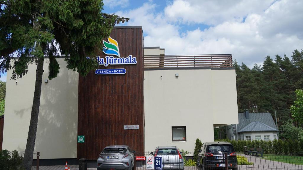 a building with cars parked in front of it at Bella Jūrmala ApartHotel in Jūrmala