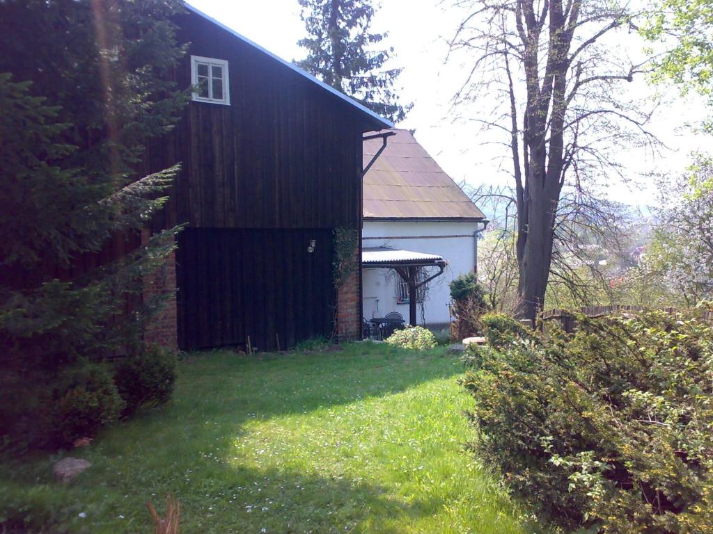 a black building with a gazebo in a yard at Chalupa v soukromí Chřibská in Chřibská