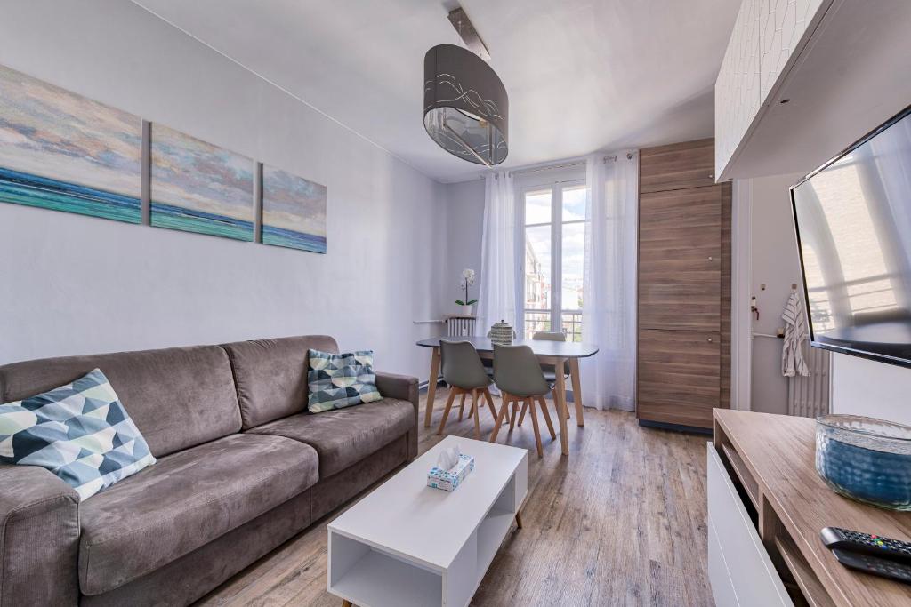 sala de estar con sofá y mesa en Confortable 3 pieces, capitale Paris, en Nogent-sur-Marne