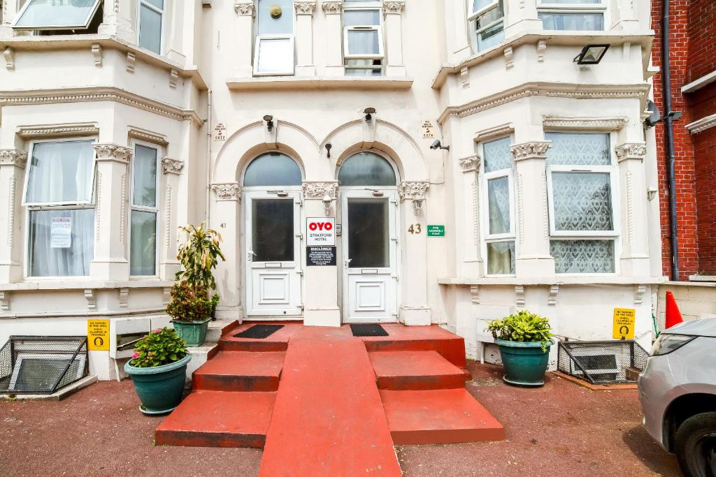 a red walkway leading to the front door of a building at Stratford Hotel in London