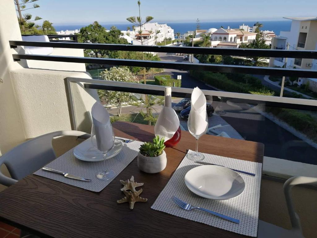 un tavolo con piatti e bicchieri da vino su un balcone di Sea View 3 ad Albufeira