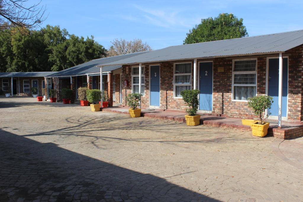 un bâtiment en briques avec des plantes en pot devant lui dans l'établissement Opstal Guestfarm, à Potchefstroom