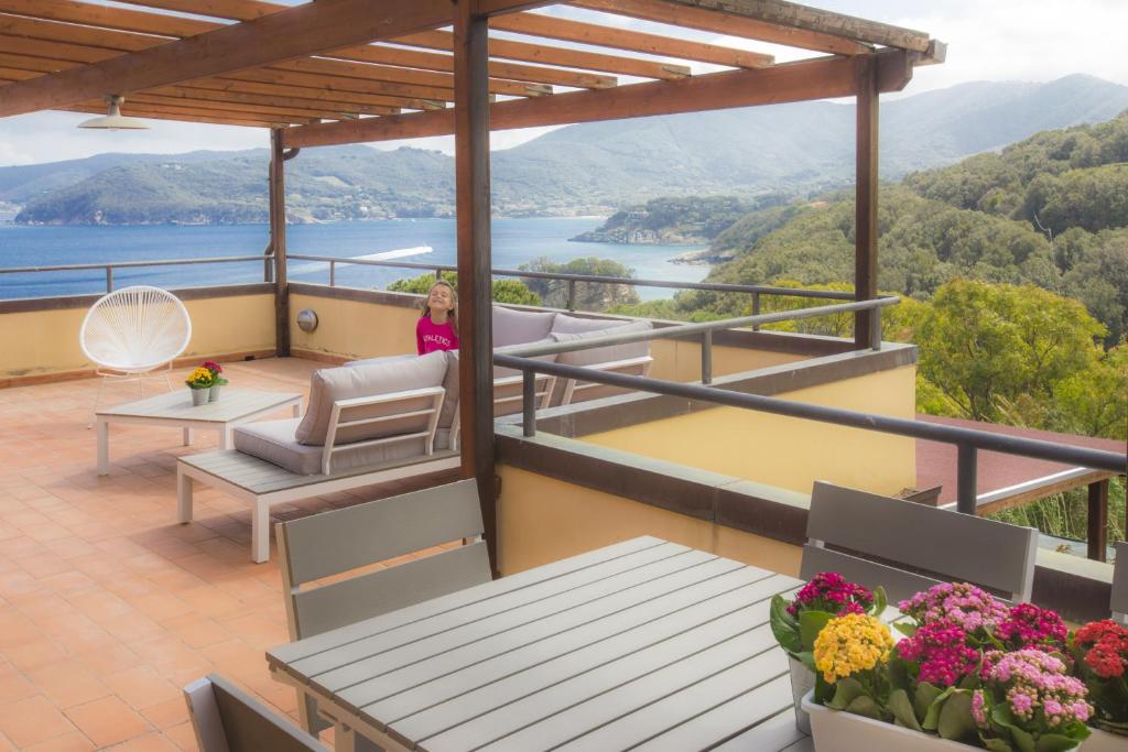 a woman sitting on the balcony of a house at Venere Paolina - Goelba in Marciana