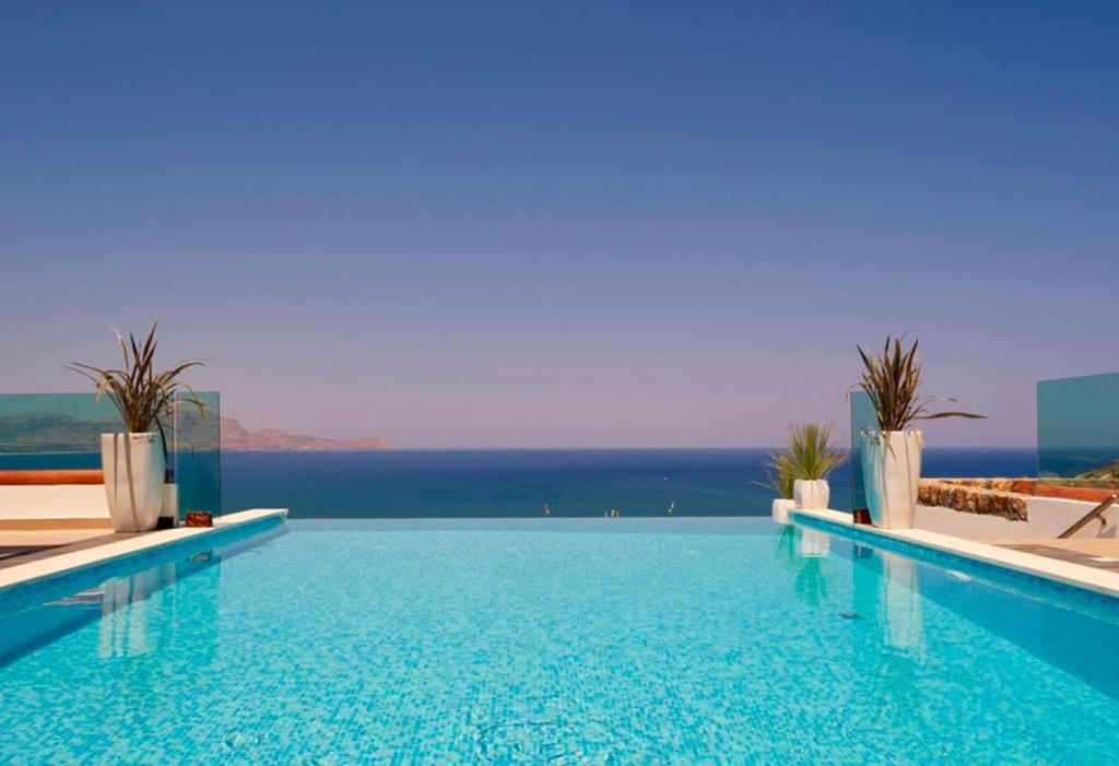 a large swimming pool with a view of the ocean at Luxury Villa Eos in vlicha