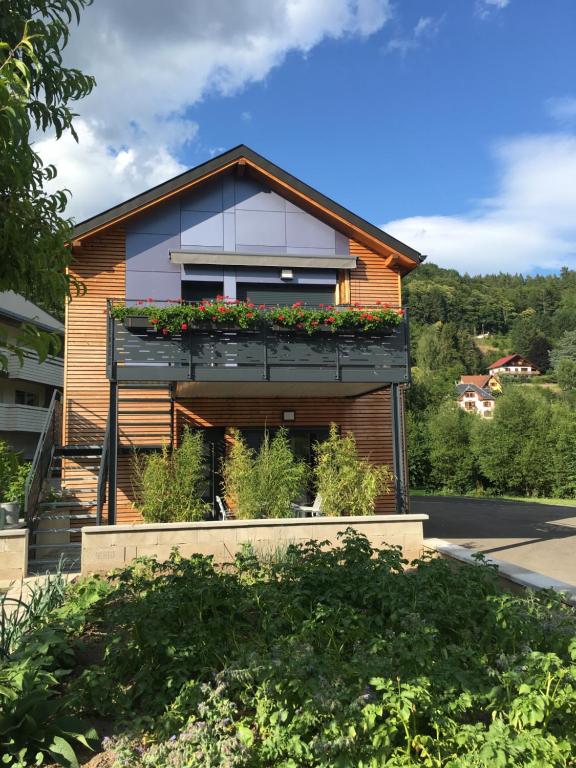 ein Haus mit einem Fenster mit Blumen darauf in der Unterkunft Au Jardin de Lina in Lapoutroie