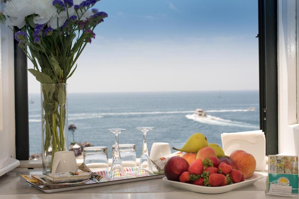 a table with a plate of fruit and a view of the ocean at Dimore De Luca- Sea View in Amalfi