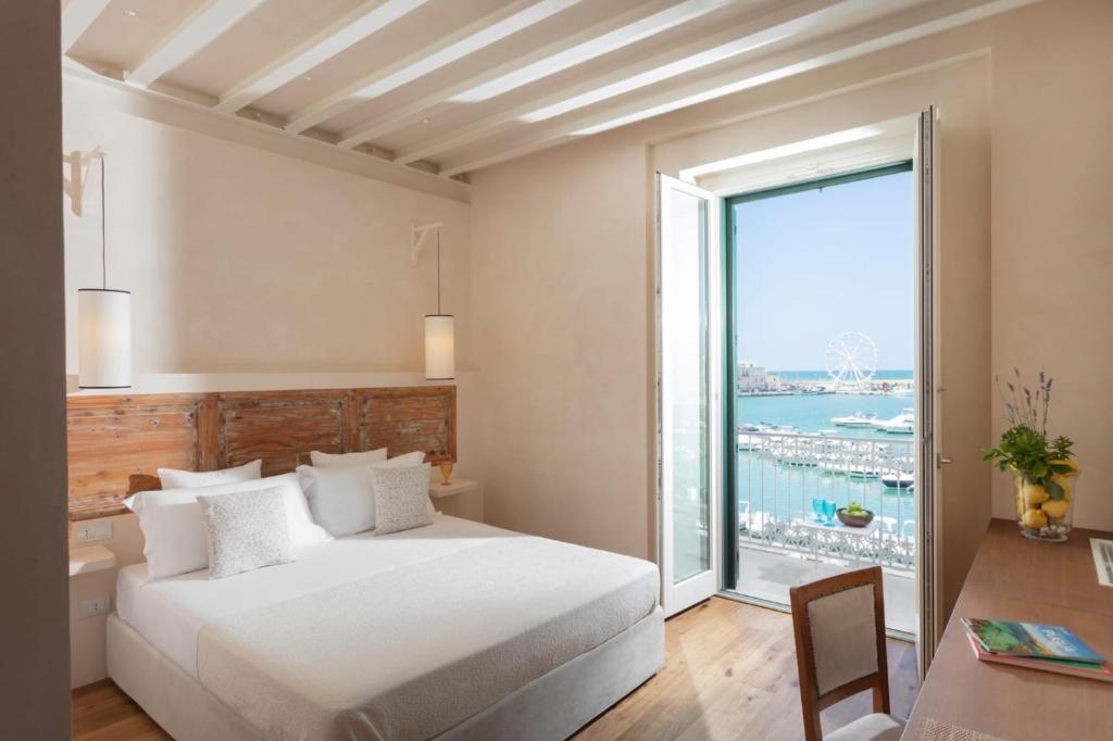 a bedroom with a bed and a large window at Dimore Marinare in Trani