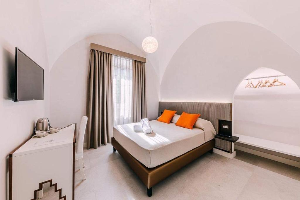 sypialnia z dużym łóżkiem z pomarańczowymi poduszkami w obiekcie Maera B&B Ravello w mieście Ravello