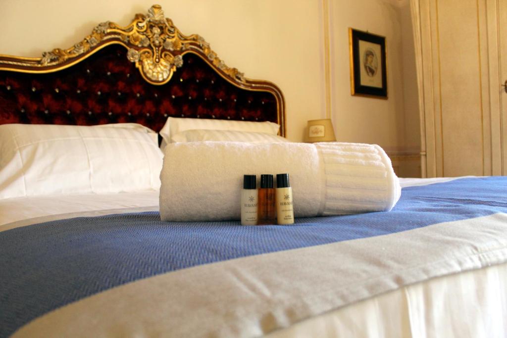 a pile of towels sitting on top of a bed at Les Suite Royales in Sassari