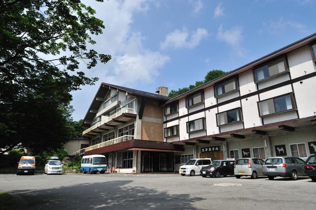 a large building with cars parked in front of it at Mogamitakayu Zenshichinoyu Ohira in Zao Onsen