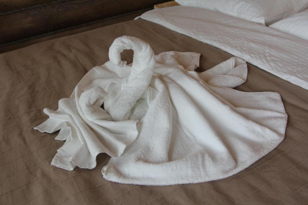 Una toalla blanca sobre una cama en Art-eco-hotel Altai, en Bisk