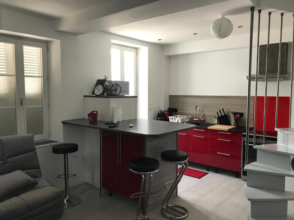 une cuisine avec un comptoir et des tabourets dans une pièce dans l'établissement Petite maison de Ville, à Auxerre