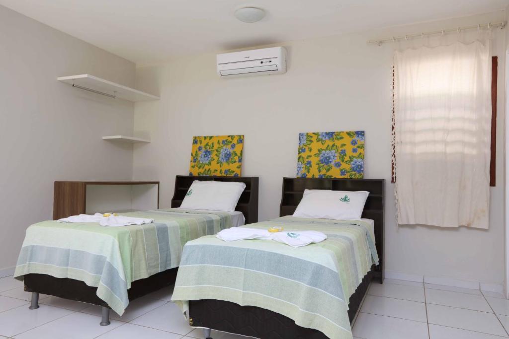 a room with two beds with towels on them at Porto Seguro Flat in Pecém