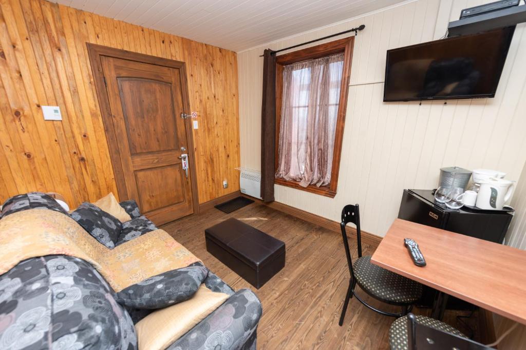 Una televisión o centro de entretenimiento en Auberge Le Four à Pain